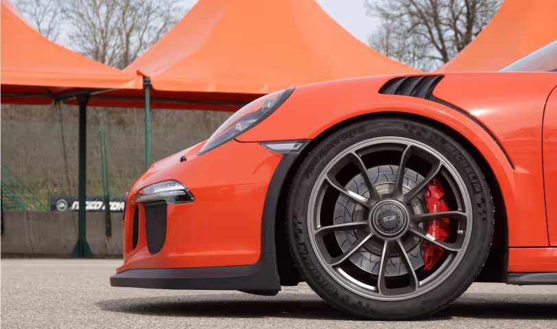 Vue de profil d'une GT3 RS Orange lors d'un stage de pilotage